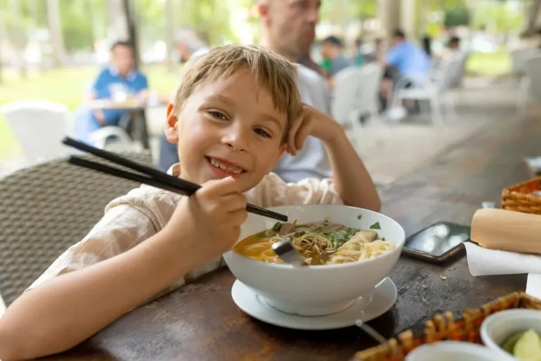 intrepid-travel-vietnam-family-child-food-pho-restaurant-shutterstock_2665357713